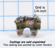 Drum on blocks cut in half and filled with junk 